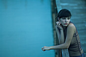 Woman leaning on railing of pier, looking away