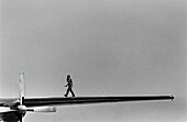 Woman walking on wing of airplane, b&w