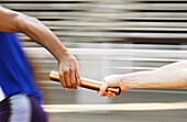 Athletes passing relay baton