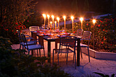 Decorated garden table with flaming torches in the evening light, Bavaria, Germany