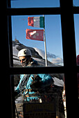 Italy, Aosta valley, climber seen through window of Teodulo mountain hut