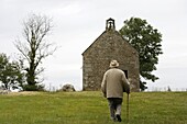 France, Mont-Dol, Man walking up to Mont-Dol chapel