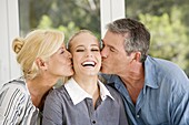 Mature couple kissing a young woman