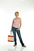 Woman with bag smiling for camera, studio shot