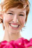 Portrait of young smiling woman, flower petals