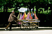 France, Paris, Tuileries garden, man pushing cart of model boats