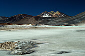 Chile, San Pedro de Atacama, Laguna de Aguas Calientes, frozen water in the foreground