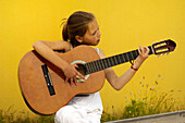 Little girl playing classical guitar