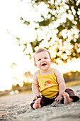 Smiling Child Sitting on Beach, Stratford, Connecticut, USA