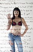 Girl Wearing Jeans and Bra Standing Behind Stream of Consciousness Text