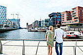 Couple looking over harbor basin, Magellan-Terraces, HafenCity, Hamburg, Germany