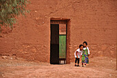 Children at Ait Benhaddou, two girls in front of the entrance, Ait Benhaddou, Atlas Mountains, South of the High Atlas, Morocco, Africa
