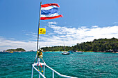Thailändische Fahne im Wind und Boote in einer Bucht, Similan Inseln, Andamanensee, Indischer Ozean, Khao Lak, Thailand, Asien