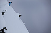 Female skier standing on a steep slope, Chandolin, Anniviers, Valais, Switzerland