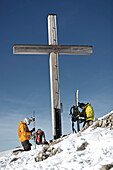 Zwei Snowboarder bei einem Gipfelkreuz, Oberjoch, Bad Hindelang, Bayern, Deutschland