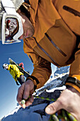 Snowboarder preparing a climbing rope, Oberjoch, Bad Hindelang, Bavaria, Germany