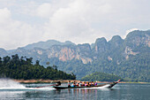 Longtailboot mit Touristen auf dem Stausee des Khao Sok Nationalparks, Khao Sok Nationalpark, Andamanensee, Thailand