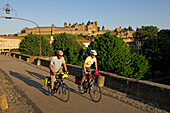 Two cyclists in front of Carcasonne castle, Midi, France