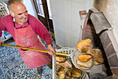 Man baking bread, Rifugio Agrituristico Salvin, Monastero di Lanzo, Piemont, Italy