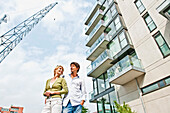 Couple near modern apartment building, HafenCity, Hamburg, Germany