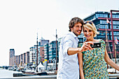 Couple taking photograph of themselves, Magellan-Terraces, HafenCity, Hamburg, Germany