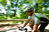 Man road cycling in forest, Bergisches Land, North Rhine-Westphalia, Germany