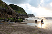 Zwei Personen am Strand in der Abenddämmerung, San Vicente de la Barquera, Kantabrien, Spanien