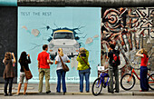 Menschen vor einem Bild der East Side Gallery, Berliner Mauer, Mühlenstrasse, Berlin, Deutschland, Europa