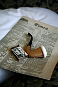 Smoking pipe, box of match sticks and old newspaper