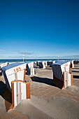 Roofed wicker beach chairs at promenade, Norderney, East Frisian Islands, Lower Saxony, Germany