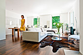 Woman going through a modern living room, Hamburg, Germany