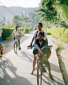 Kids riding their bikes to school, Anse La Reunion, La Digue, La Digue and Inner Islands, Republic of Seychelles, Indian Ocean