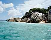 Tourists on the beach of tiny Coco Island, La Digue and Inner Islands, Republic of Seychelles, Indian Ocean