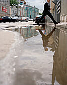 Pedestrian crossing a puddle in Wolchonka Uliza street, Moscow, Russia, Europe