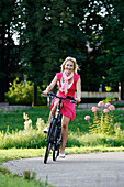 Frau fährt E-Bike, Radtour, Rosensteinpark, Stuttgart, Baden-Württemberg, Deutschland
