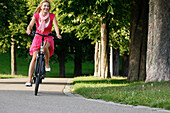 Frau fährt E-Bike, Radtour, Rosensteinpark, Stuttgart, Baden-Württemberg, Deutschland