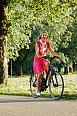 Frau fährt E-Bike in Rosensteinpark, Radtour, Stuttgart, Baden-Württemberg, Deutschland