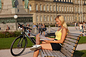 Woman having a break after a bike tour, e-bike, Schlossplatz, New Castle, Stuttgart, Baden-Wurttemberg, Germany
