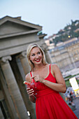 Woman drinking a cocktail outside Konigsbau, Schlossplatz, New Castle, Stuttgart, Baden-Württemberg, Germany