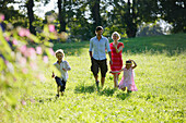 Family walkikng over meadow, Lake Starnberg, Bavaria, Germany