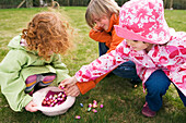 3 children in garden with Easter eggs