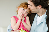 Man kissing little girl's forehead