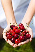 Young woman holding cherries