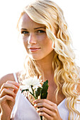 Young woman holding a white flower