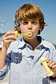 Boy blowing bubbles with a bubble wand