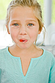 Portrait of a girl eating a candy