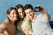 Three friends taking a picture of themselves with a digital camera