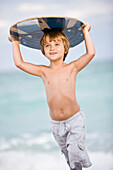 Boy holding a body board over his head