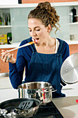 Woman tasting food in the kitchen