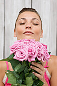 Woman smelling pink roses